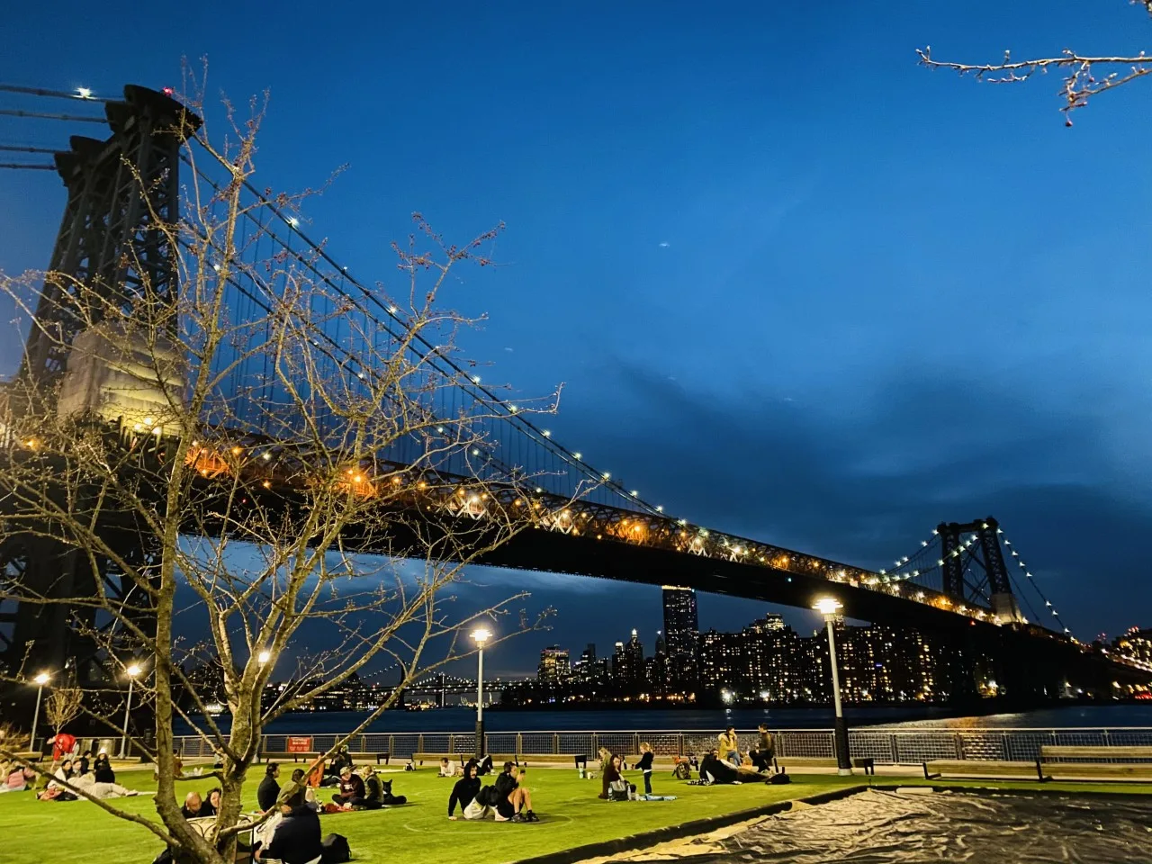 Le Williamsburg Bridge au-dessus du parc riverain en soirée